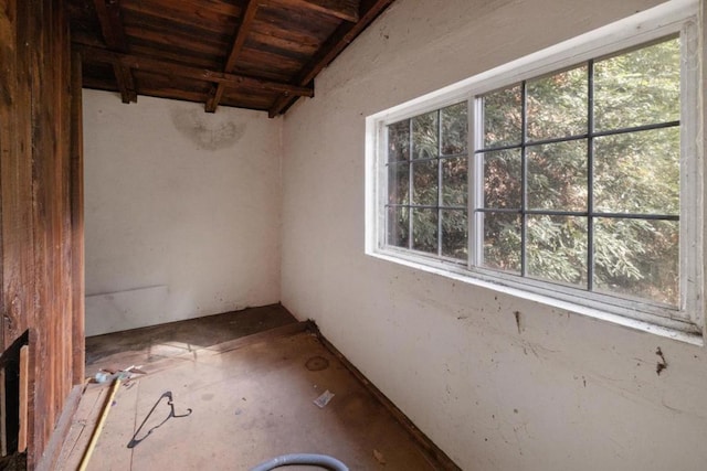 spare room featuring lofted ceiling with beams and wooden ceiling