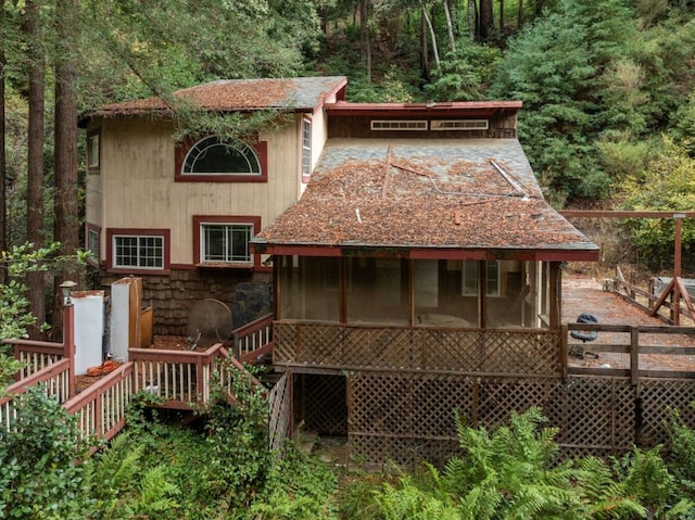 back of property with a sunroom