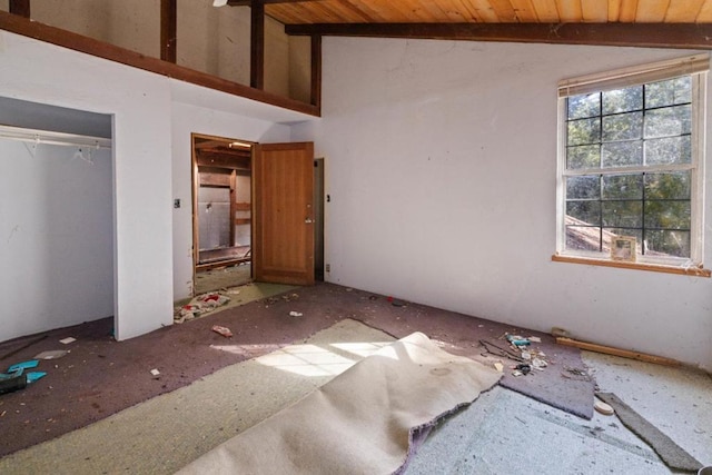 unfurnished bedroom with vaulted ceiling with beams, a closet, and wood ceiling