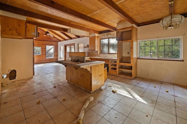 kitchen featuring vaulted ceiling with beams, plenty of natural light, kitchen peninsula, and a breakfast bar