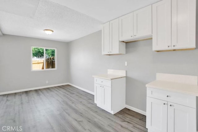 interior space featuring light wood-type flooring and a textured ceiling