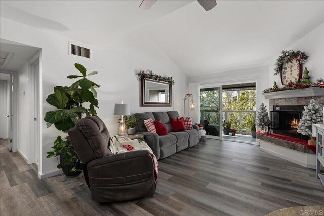 living room with a fireplace, vaulted ceiling, and dark hardwood / wood-style flooring