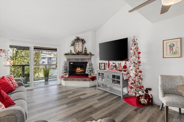 living room with ceiling fan, a premium fireplace, hardwood / wood-style floors, and vaulted ceiling