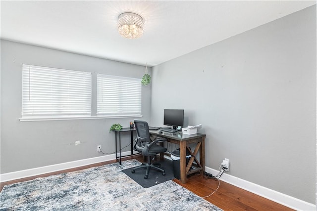 home office with hardwood / wood-style floors and a notable chandelier