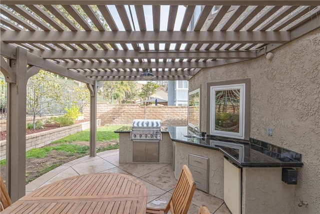 view of patio with an outdoor kitchen, area for grilling, a pergola, and sink