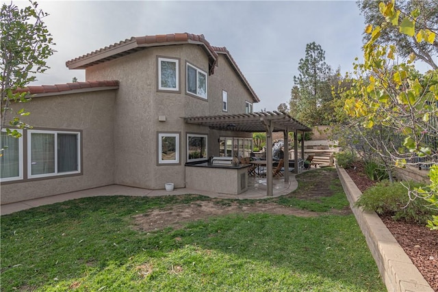 rear view of house with a pergola, a patio area, and a yard