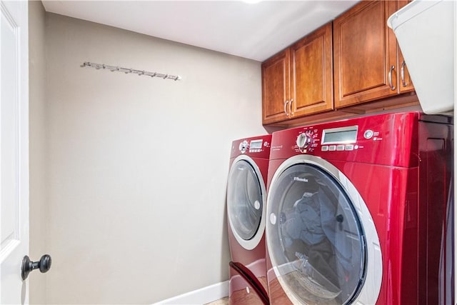 laundry area featuring washer and clothes dryer and cabinets