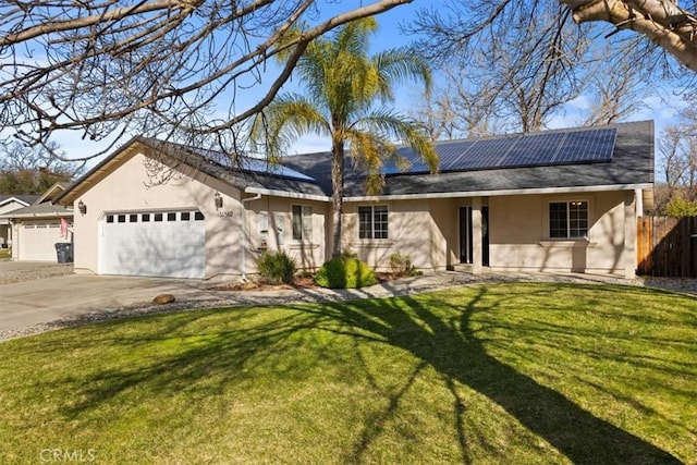 ranch-style home with a garage, a front yard, and solar panels