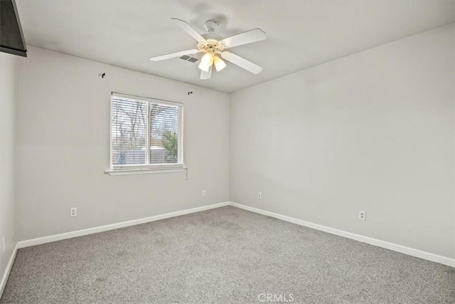 carpeted spare room featuring visible vents, ceiling fan, and baseboards