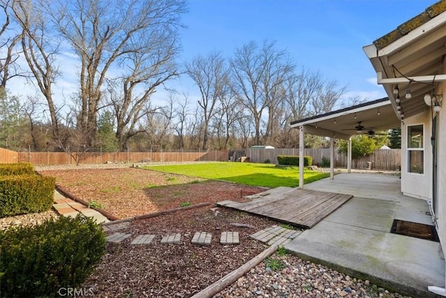 view of yard featuring a fenced backyard, a patio area, and ceiling fan