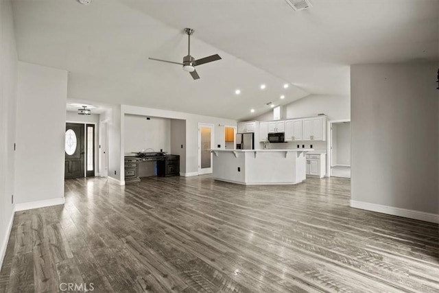unfurnished living room featuring visible vents, a ceiling fan, baseboards, dark wood-style flooring, and vaulted ceiling