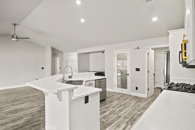 kitchen with a breakfast bar area, appliances with stainless steel finishes, dark hardwood / wood-style floors, a kitchen island with sink, and sink