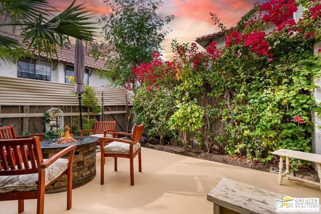 patio terrace at dusk featuring an outdoor fire pit