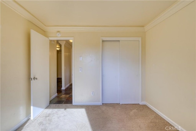 unfurnished bedroom with a closet, carpet, and ornamental molding