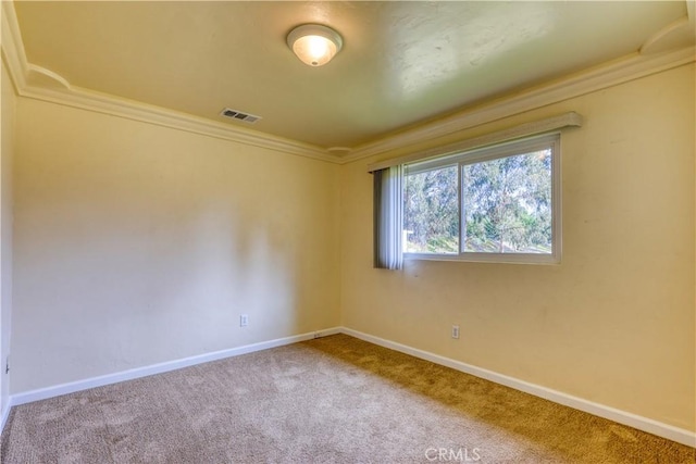 empty room featuring crown molding and carpet