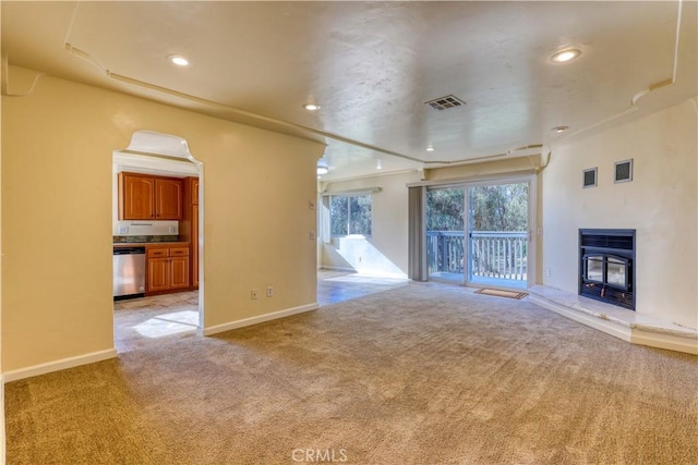 unfurnished living room with a wood stove and light carpet