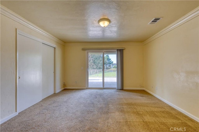 carpeted spare room featuring crown molding