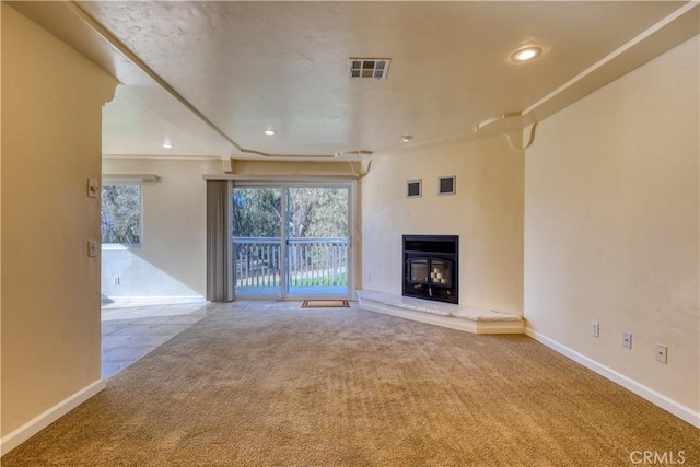 unfurnished living room with carpet flooring and a wood stove