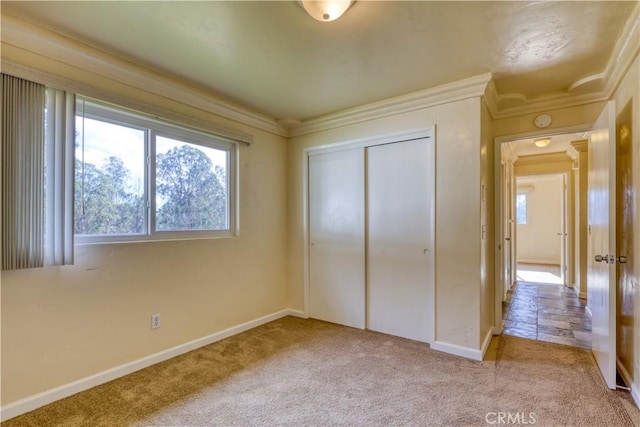 unfurnished bedroom featuring light carpet, a closet, and ornamental molding