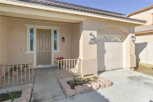 entrance to property featuring a porch and a garage