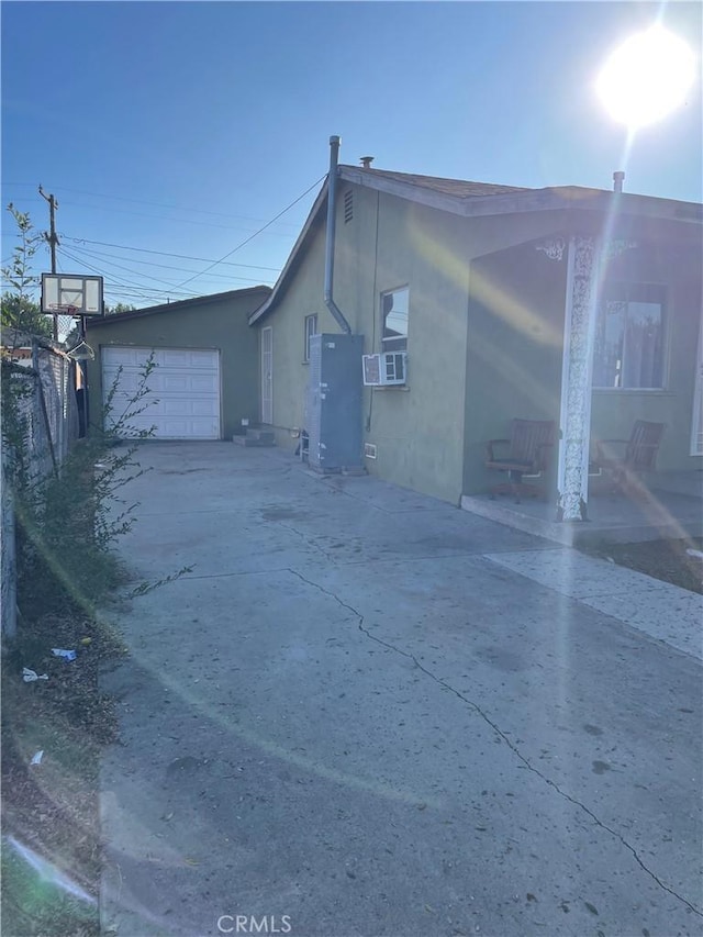 view of property exterior featuring cooling unit and a garage