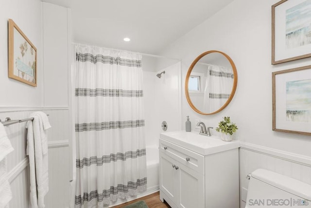 full bathroom featuring hardwood / wood-style flooring, shower / bath combination with curtain, toilet, and vanity