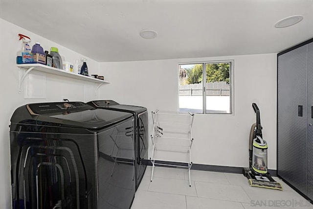 clothes washing area with light tile patterned floors and separate washer and dryer