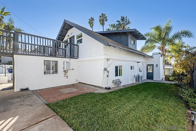 back of house with a patio area and a yard