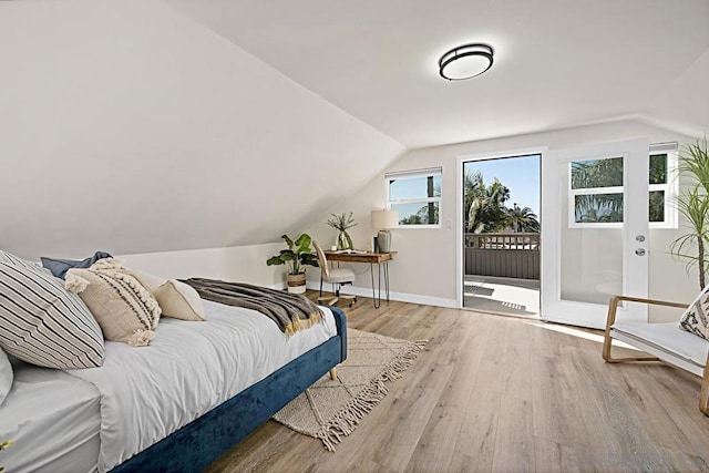 bedroom with access to exterior, lofted ceiling, and light wood-type flooring