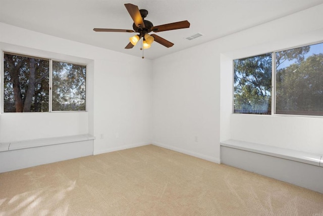 unfurnished room featuring light carpet and ceiling fan