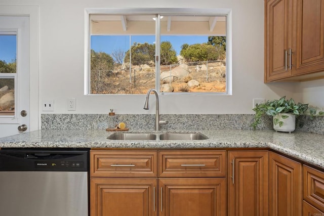 kitchen with stainless steel dishwasher, plenty of natural light, and sink