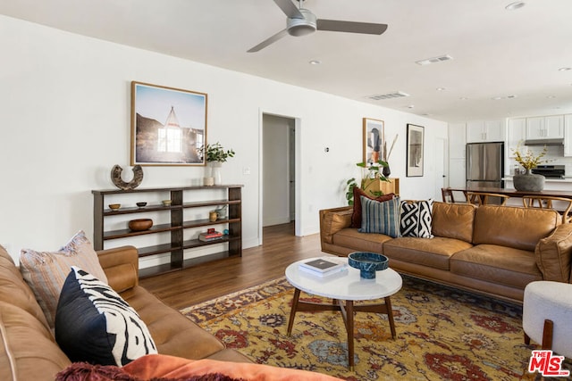 living room with ceiling fan and dark wood-type flooring