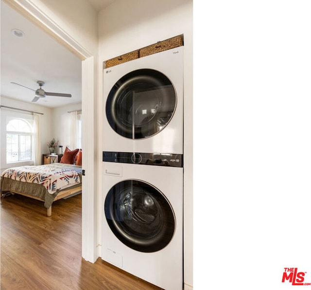 laundry room featuring stacked washer / dryer, ceiling fan, and hardwood / wood-style flooring