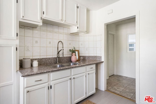 kitchen with backsplash, white cabinetry, sink, and light tile patterned flooring