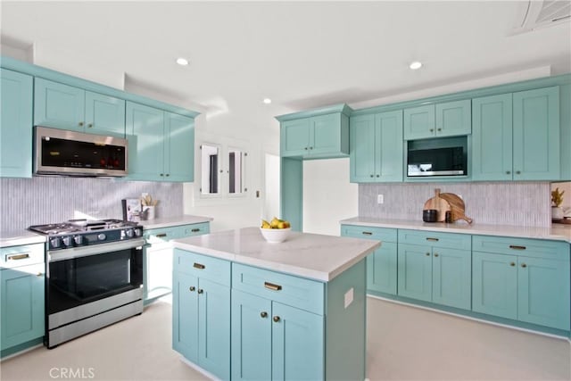 kitchen featuring backsplash, light stone counters, a center island, and appliances with stainless steel finishes