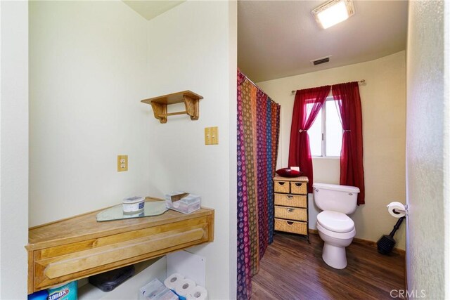 bathroom featuring hardwood / wood-style floors and toilet