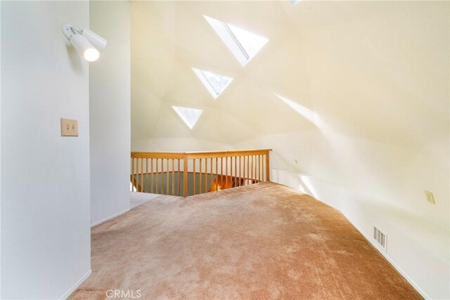 bonus room with a skylight and carpet flooring