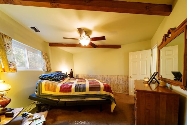 bedroom featuring ceiling fan, carpet floors, and beamed ceiling