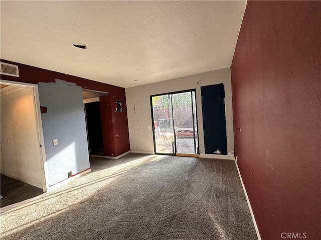 carpeted empty room featuring a textured ceiling