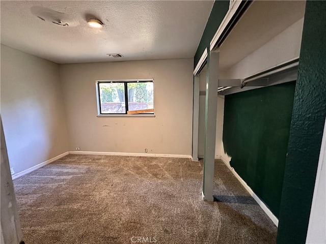 unfurnished bedroom featuring carpet and a textured ceiling