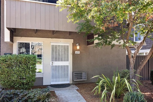 property entrance featuring fence and stucco siding