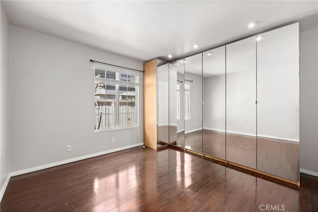 unfurnished bedroom featuring dark wood finished floors and baseboards