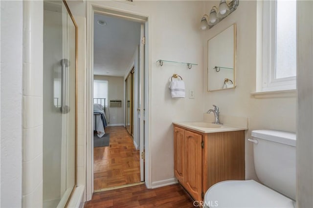 bathroom featuring vanity, toilet, parquet floors, and a wealth of natural light