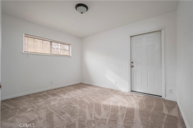 unfurnished room featuring light carpet