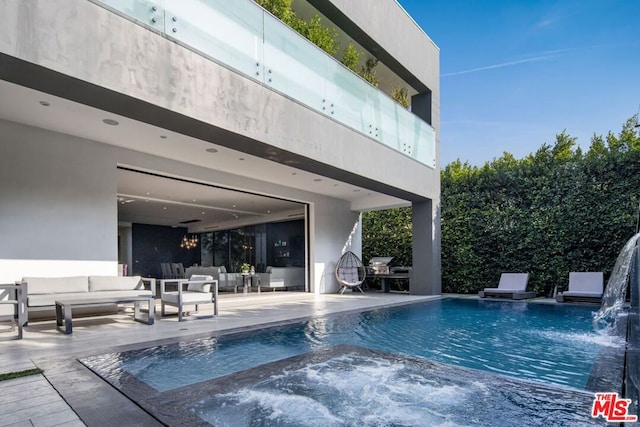 view of pool with a jacuzzi, pool water feature, a patio, and an outdoor hangout area