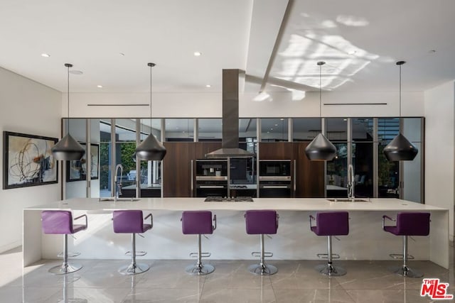 kitchen with a large island, sink, a breakfast bar area, and hanging light fixtures