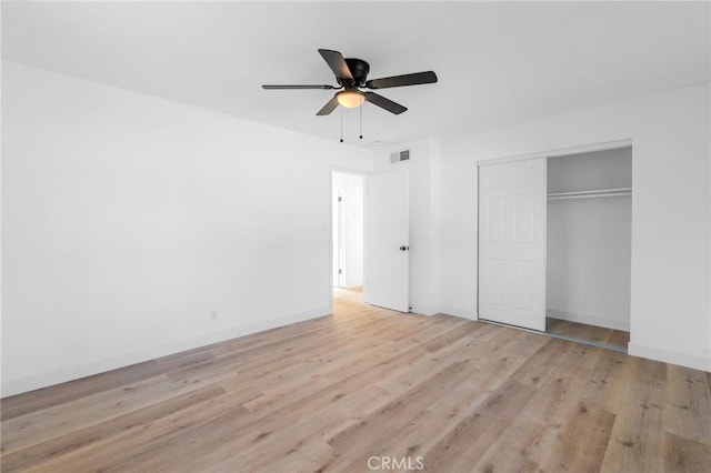 unfurnished bedroom featuring ceiling fan, a closet, and light wood-type flooring