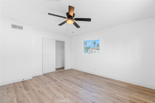 unfurnished bedroom with ceiling fan, light wood-type flooring, and a closet