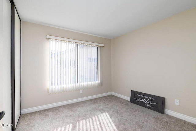 unfurnished room featuring light carpet