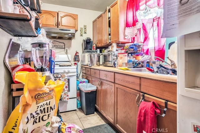 kitchen with gas range gas stove, sink, and light tile patterned floors